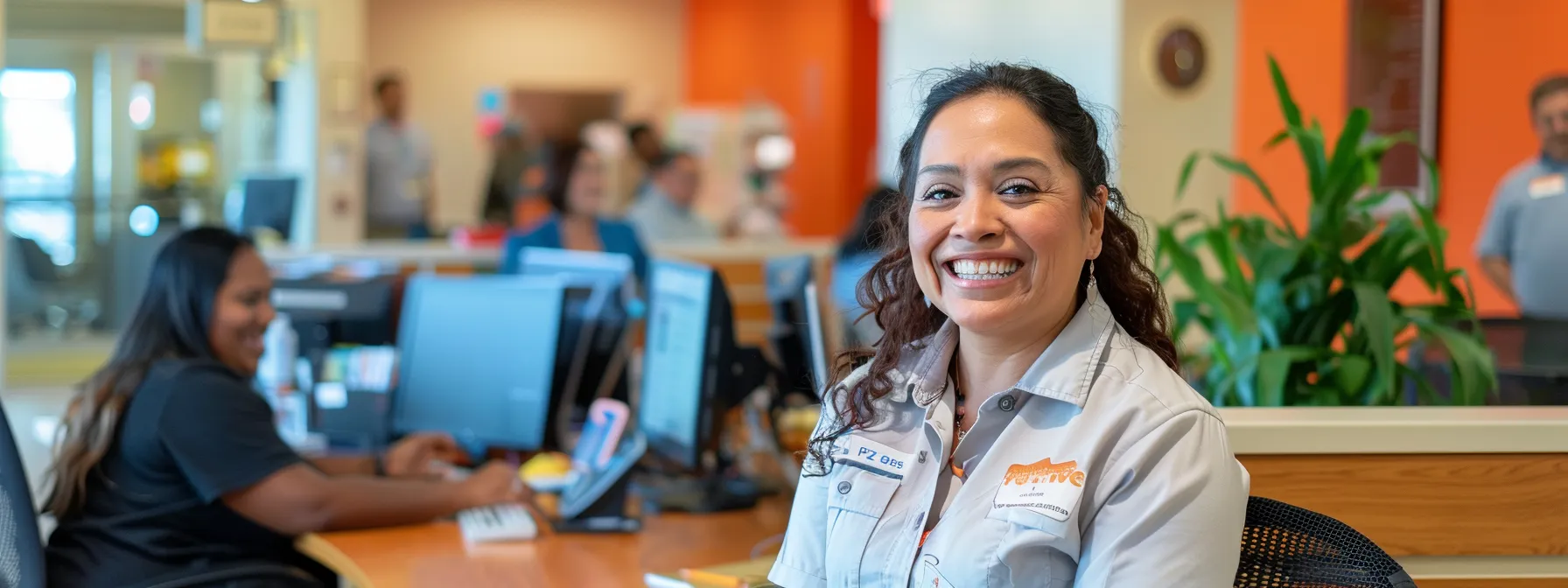 a smiling medicare customer service representative assisting a diverse group of clients in a modern office setting in arizona.